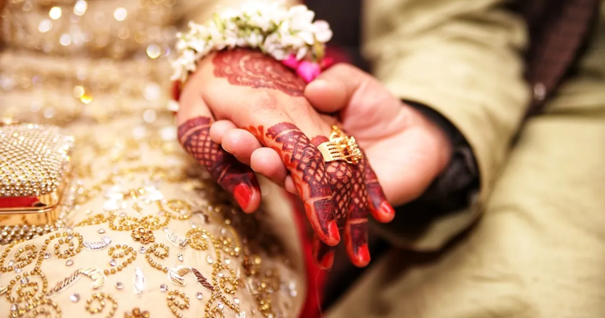 A Pakistani wedding couple in traditional attire, representing the love story that begins a family's history