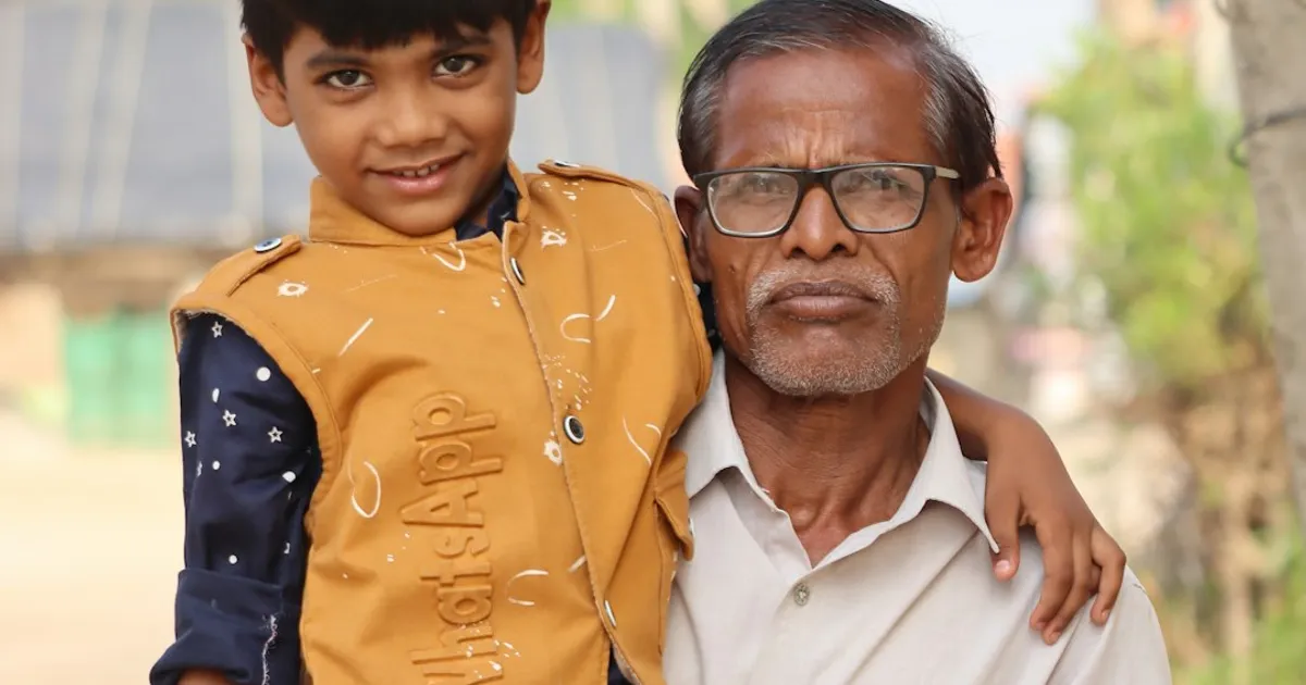 A young boy posing happily with his grandfather in a warm family moment
