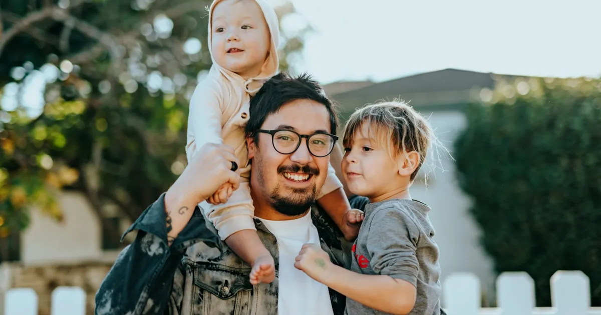 A father carrying his young daughter in a warm embrace, representing the bond between generations and the passing down of family stories